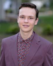 Arthur in purple suit smiling