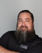 Paul crossing arms in black ivy tech shirt